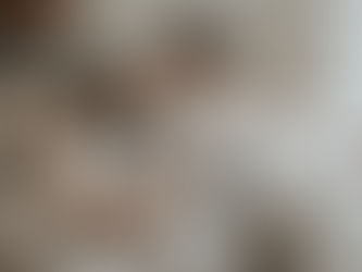 Natürliche Babyfotos zuhause in Wien - Eltern kuscheln mit Baby auf ihrem Sofa