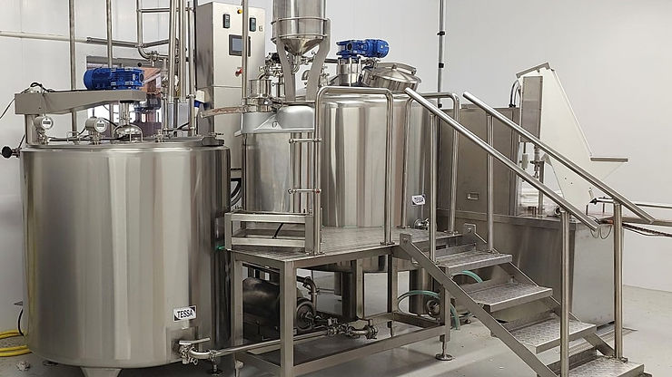 Batch pasteurizers, stainless steel tanks, and cheese vats for dairy processing.