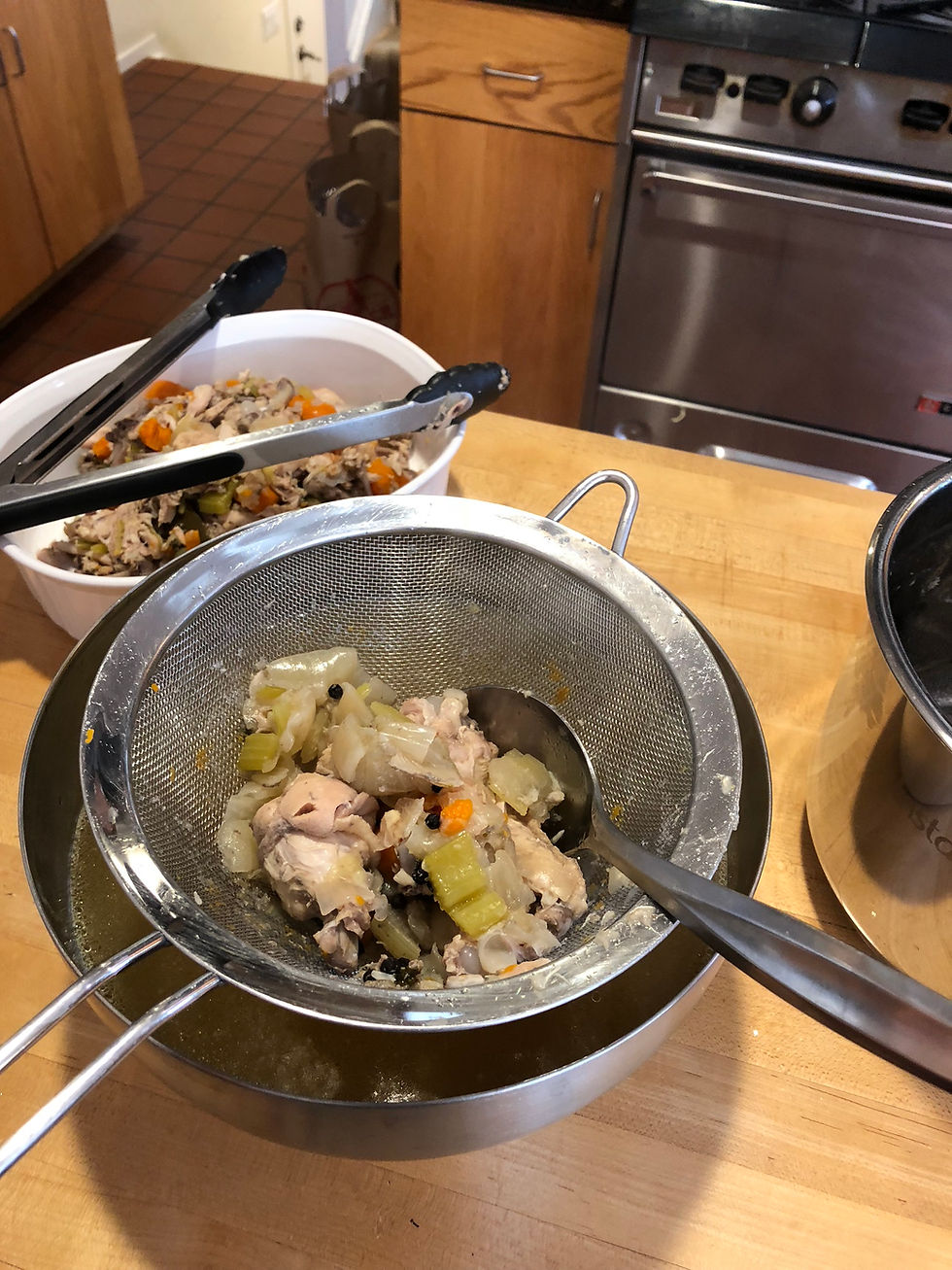 If you doing this right after the pressue naturally release keep in mind that everything is still very hot. Scoop out some of the vegetables and chicken and place in the strainer. Carefully, pour the broth thru the strainer ...remember it's hot! Keep the golden broth and discard everything else.