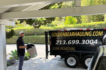 Golden Bear Hauling and Junk Removal team standing beside a fully loaded truck after completing a full day of hauling jobs.