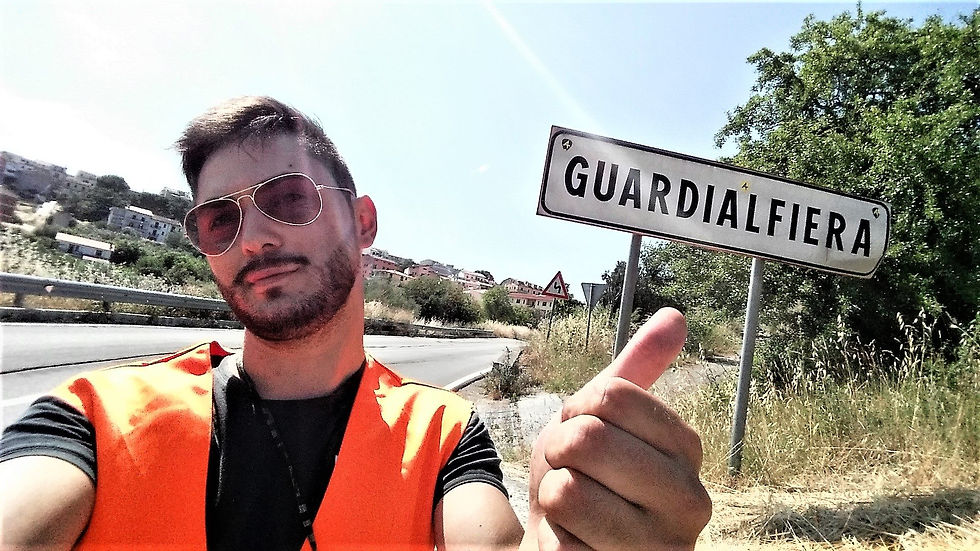 Il blogger molisano Molise On The Road con alle spalle il cartello di Guardialfiera