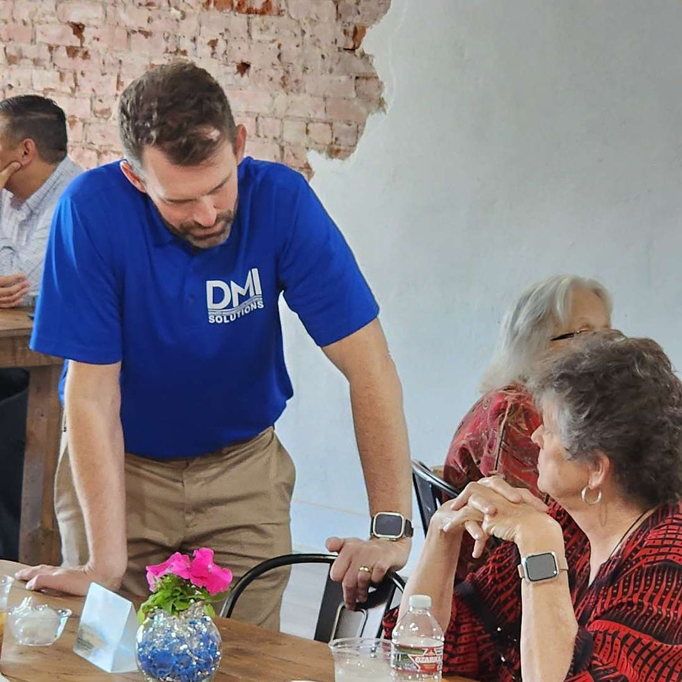 DMI team engaging with clients during a community luncheon, reflecting personalized service and local care