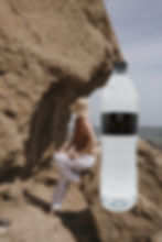 Peninsula Springs Still 1 Litre bottle with woman on rocks by the sea