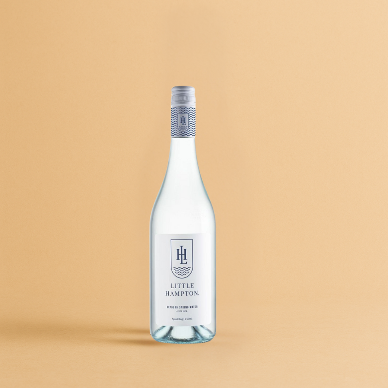 Little Hampton Sparkling Water bottle with logo, Acqua Sorrento on peach background.