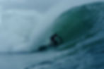 surfer noah lane getting barrelled on a big wave ridding a twin fin surfboard in winter in ireland