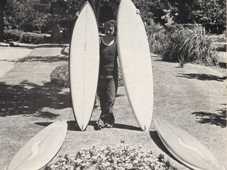 surfboard shaper peter "chops" lascelles standing with a quiver of surfboards in 1978