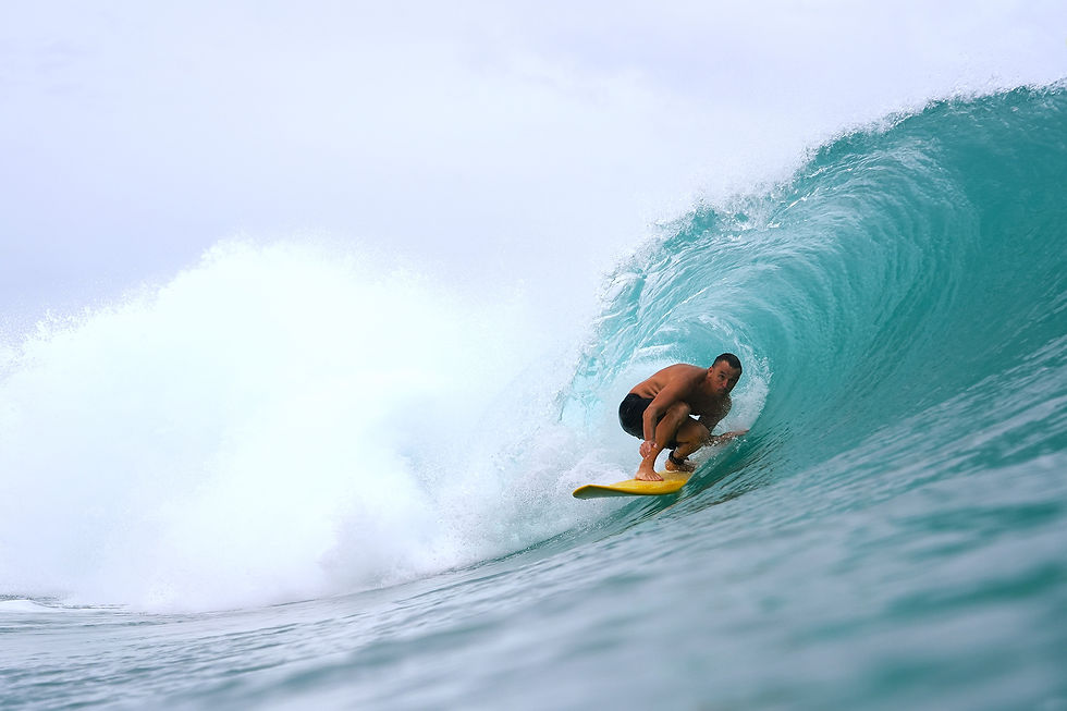 surfer in the barrel on a yellow surfboard at macaronis in the mentawai islands