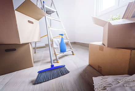 A Tucson home in transition, with scattered cleaning supplies, boxes, and a step ladder signaling an active house cleaning process. Natural light spills over hardwood floors, capturing a moment of preparation before the space is refreshed and ready.