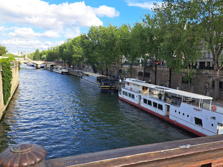 A photo of the Seine river with canal boats along the side.
