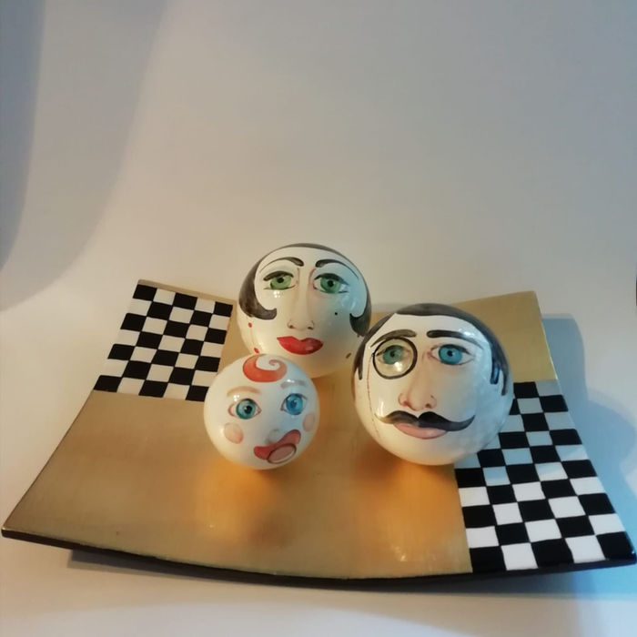 Tre sfere decorate a viso su vassoio