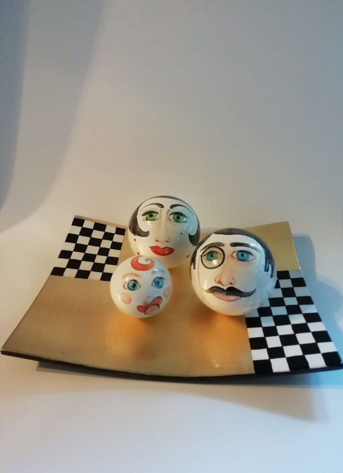 Tre sfere decorate a viso su vassoio