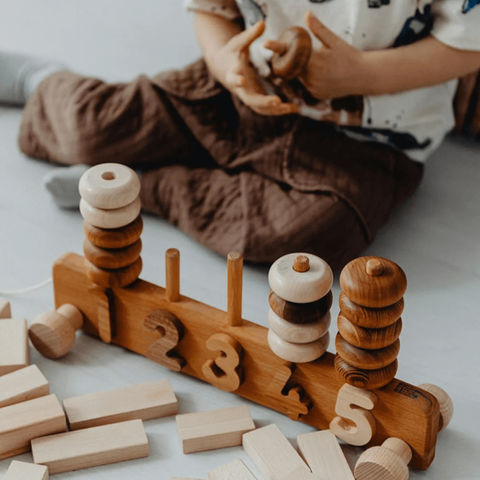 Child plays with wooden number counting toy