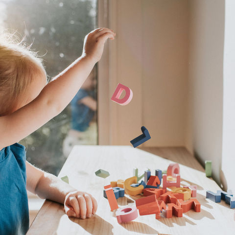 Child plays with wooden letters