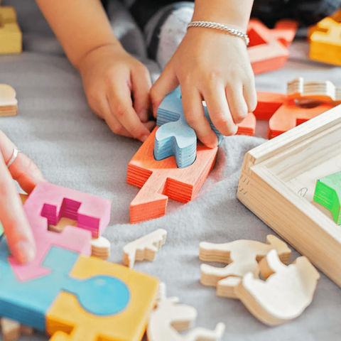 Child plays with intricate wooden puzzle toys
