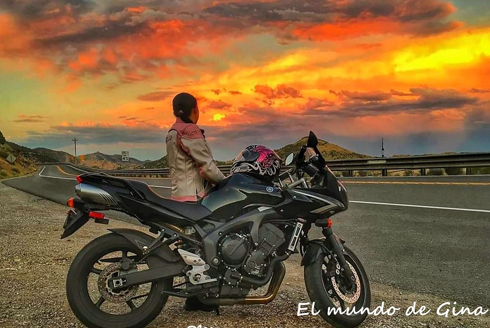 Mujeres que viajan solas por el mundo - mujer con motocicleta mirando atardecer