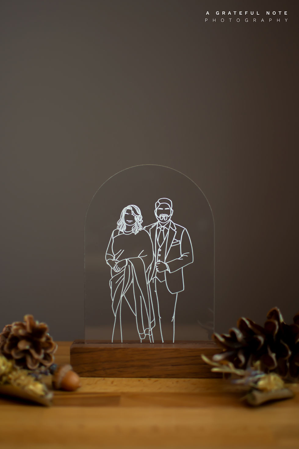 Thumbnail: South Asians Bride & Groom Minimalist Portrait Photo engraved on 4x6 Arch Acrylic Blank, sit in a Dark Wood Stand