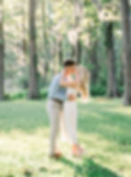 Couple kisses in Greenfield Park engagement session with sun setting through the trees.
