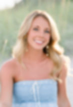 Headshot of girl in blue sleeveless dress sitting in the dune grass at Topsail Island. Gold dangling earrings.