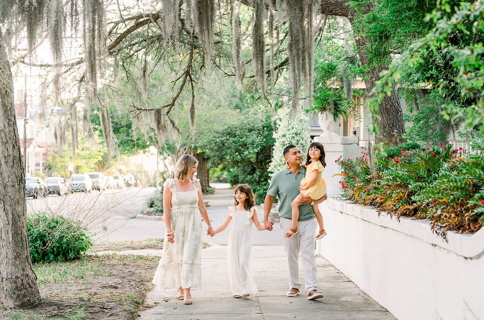 Family walking down the sidewalk in downtown Wilmington with Spanish Moss in the trees