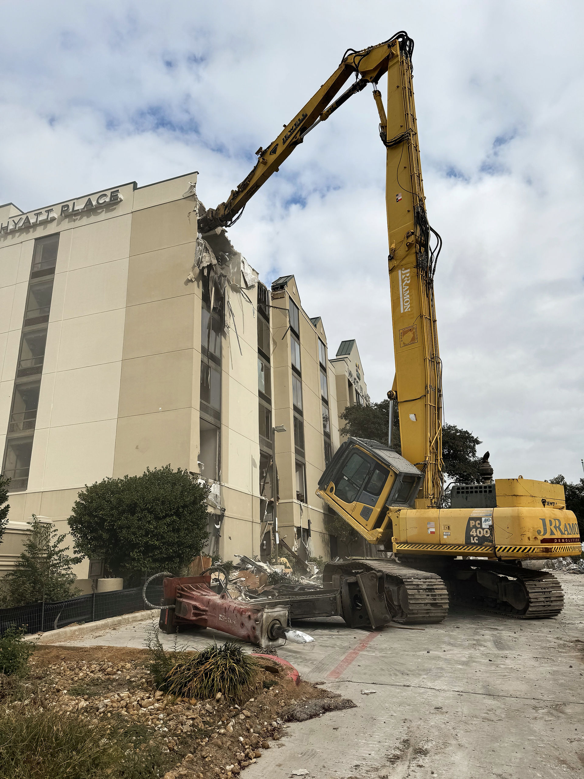 A high reach machine tears down a building. 