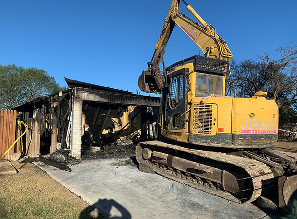 An excavator demolishes a residental building.