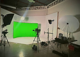 Green screen studio at Creative Block ATL with tripods, lights, and cameras—ideal for filming, YouTube, and commercial video