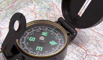 A compass sitting on top of a map