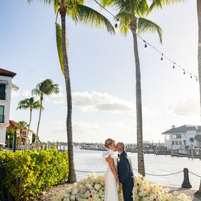 Bride and groom sharing their first kiss during outdoor wedding ceremony.