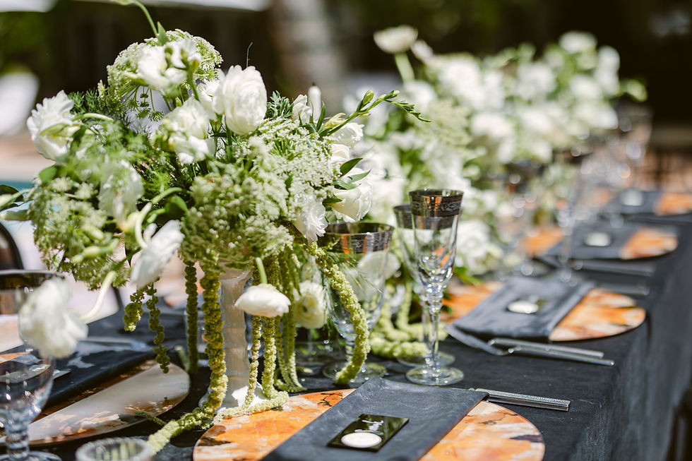 Close-up of organic modern wedding tablescape with white florals, black linens, elegant glassware, and layered place settings at Escalante Hotel.