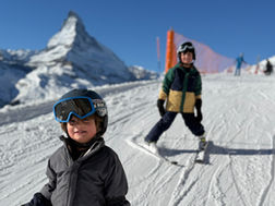 two boys skiing in front of The Matterhorn having a great day
