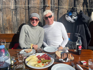 a couple enjoying a spread of various Swiss foods at a lunch spot in zermatt