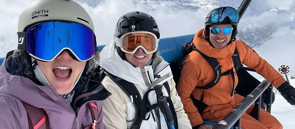 A guide and two guests laughing on a chairlift above Zermatt on a winter ski holiday