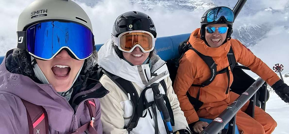 A guide and two guests laughing on a chairlift above Zermatt on a winter ski holiday