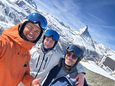 a selfie is taken of 3 people on a sunny ski day in Zermatt