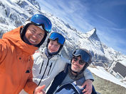a selfie is taken of 3 people on a sunny ski day in Zermatt