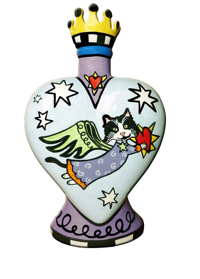 Thumbnail: Heart-shaped cat urn with black-and-white angel cat in purple robe and green wings, flying with a red heart. Topped with a ye