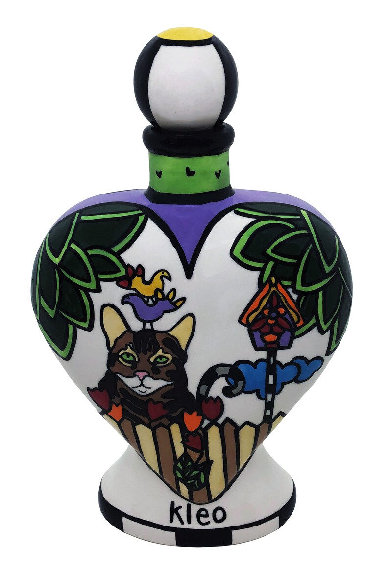 Thumbnail: Custom cat urn with “Kleo” hand-painted below tabby cat in garden with birds and heart knob on top