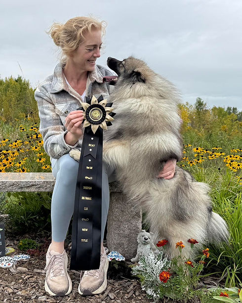 Sandi Ford of Peregrine Keeshond with one of her Dogs and a FAST CAT Ribbon