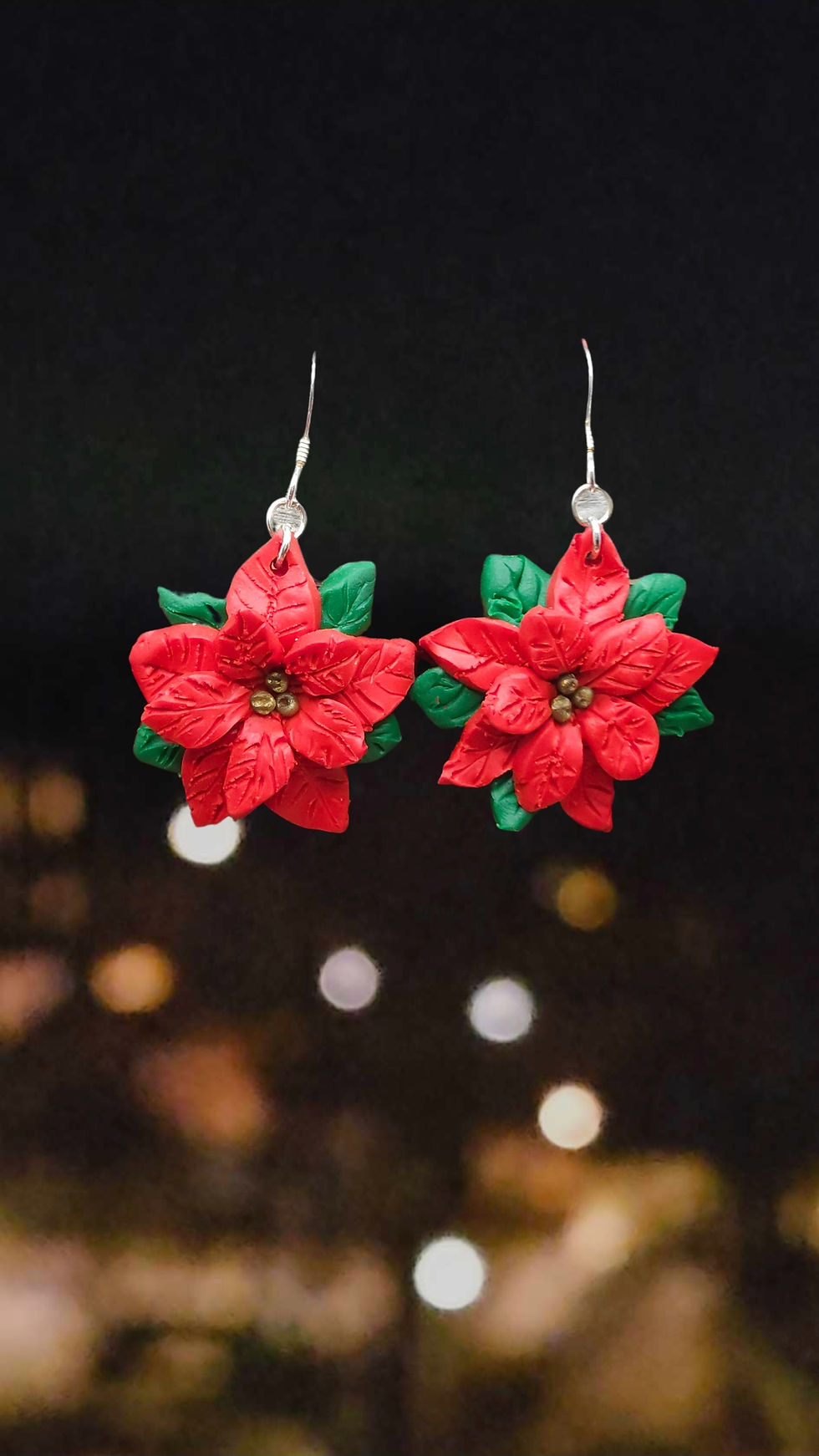 Julörhängen med röda julstjärnor mot en mörk bakgrund