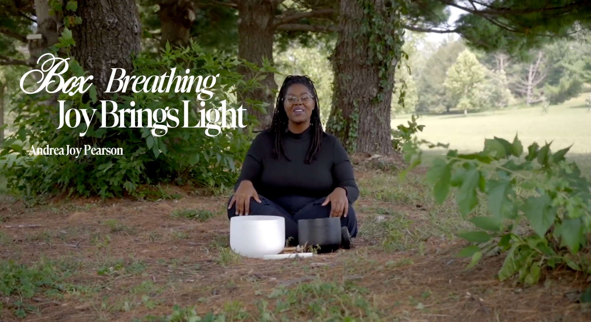 Andrea Joy Pearson seated outdoors with crystal singing bowls during the Box Breathing guided breathwork video.