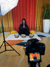 Andrea Joy Pearson being recorded while seated in front of crystal singing bowls for a custom on-demand sound healing video.