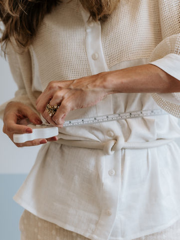 Foto de uma pessoa medindo a circunferência abdominal com uma fita de medição. 