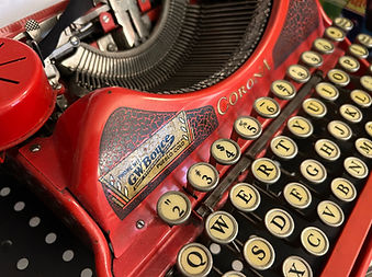 A vintage red typewriter representing Rusty MacGuffin, the haunted author