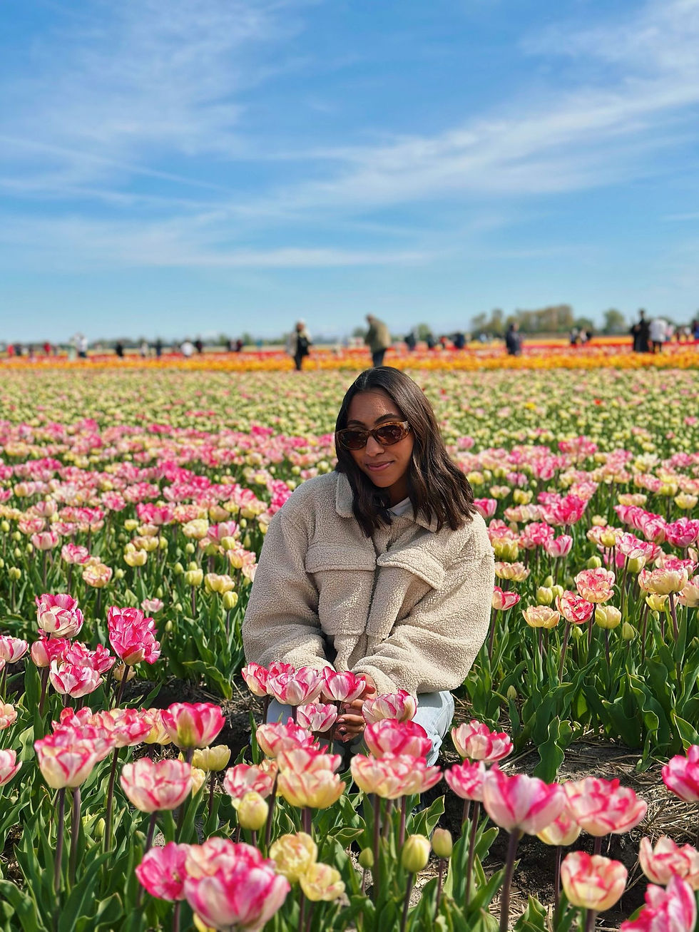 mulher no meio de um campo de tulipas de várias cores na holanda au pair
