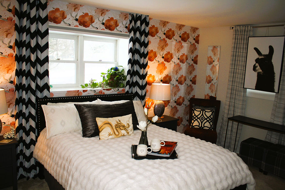 Bedroom with wallpaper adds color and depth to a strong black and white color palette.