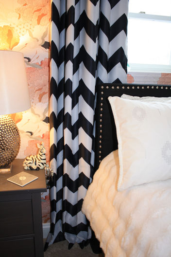Graphic wallcovering and drapery balanced with soft simple bedding.
