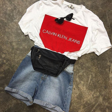 Summer outfit flat lay featuring a Calvin Klein jeans T-shirt, denim shorts, black fanny pack, and sunglasses.