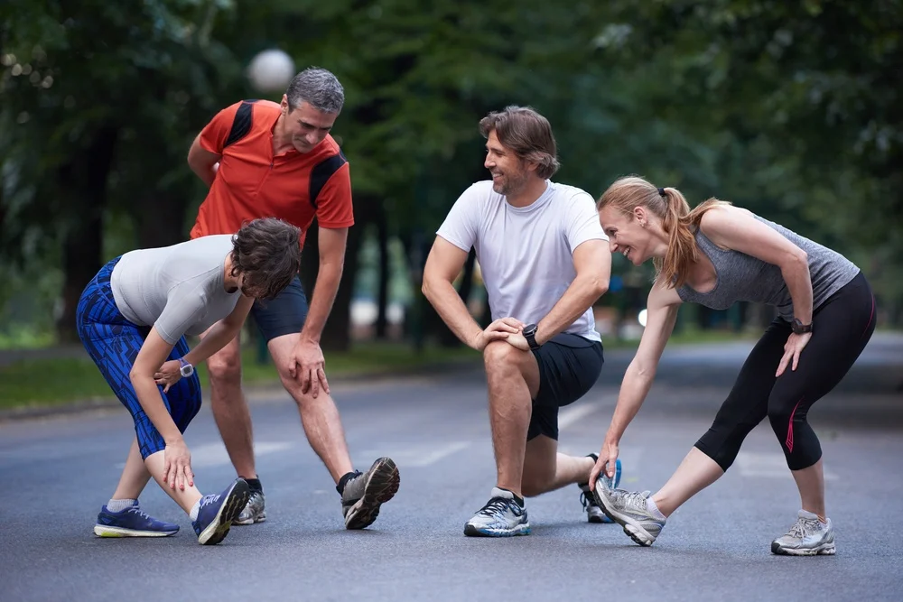 jogging people group stretching in park before training.webp