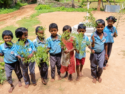 Children holding fresh Gorintaku leaves outdoors during an Ashadam tradition activity at PURE Abhyasa.