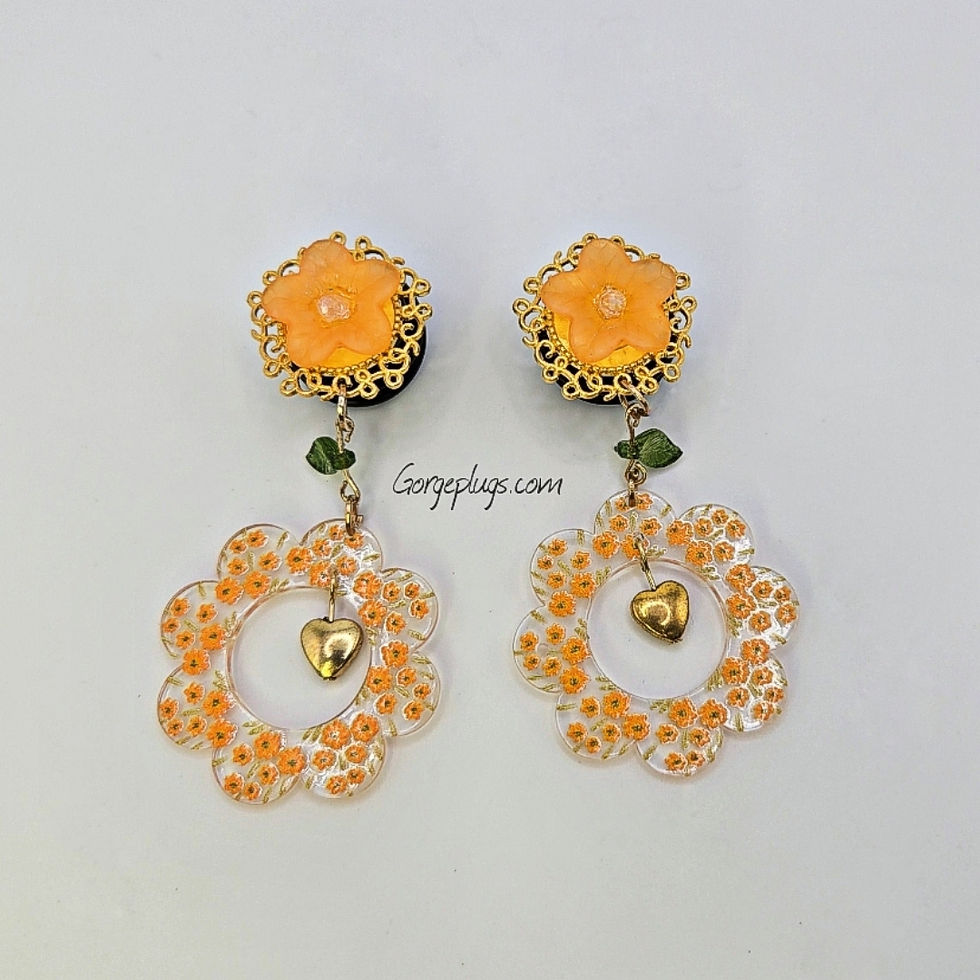 Thumbnail: Handmade floral plugs featuring gold filigree with orange resin flowers, green leaf charms, and Orange Flower Painted hoops